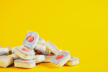 dishwasher tablets on yellow background, dishwashing products