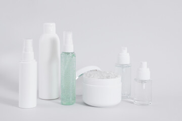 Obraz na płótnie Canvas Composition of different cosmetic bottles mock-up on gray background