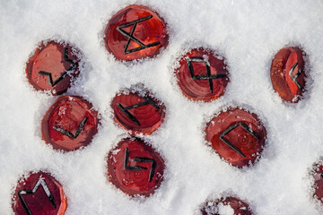 Scandinavian runes carved from wood lying in the snow