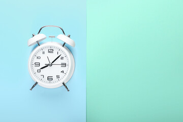 Stylish alarm clock on color background