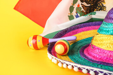 Mexican flag, sombrero and maracas on color background