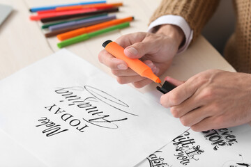 Young male calligrapher working in office, closeup