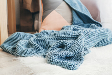 Fototapeta na wymiar Cozy place for rest with pillow and knitted plaid, closeup