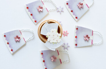 paper flower bouquet in a wooden cup surrounded by paper handbags or purses