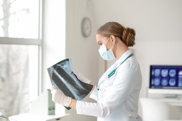 Female doctor with x-ray scan in clinic