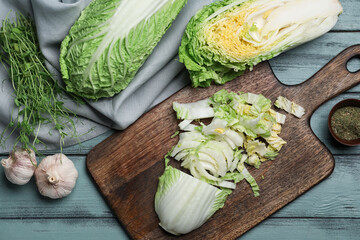 Board with fresh cut chinese cabbage on color wooden background