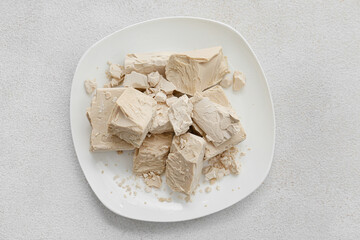 Plate with fresh yeast on light background