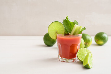 Glass of bloody mary cocktail and limes on table