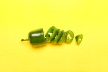 Slices of green jalapeno pepper on color background