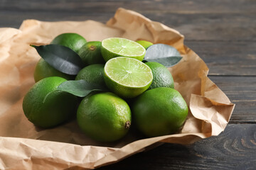 Tasty limes on dark wooden background