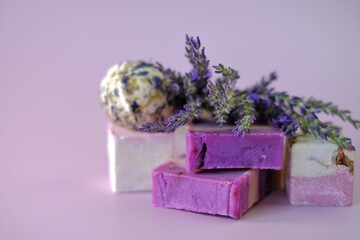 Lavender Soap and Bath Bombs, sprigs of lavender on a light purple background. vegan eco-friendly cosmetics . Organic herbal cosmetics with lavender extract. 