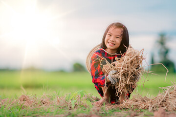 Naklejka na ściany i meble Kids holding rice straw to planting tree in garden of rural