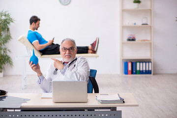 Obraz premium Young male patient visiting old male doctor gastroenterologist