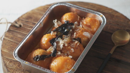 a close-up view of delectable takoyaki (Japanese octopus dumplings) topped with a savory mentai (marinated cod roe) sauce. The takoyaki balls are presented in a shallow depth of field, drawing the vie
