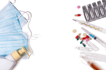 Face masks and disinfecting gel for prevention, a thermometer and medicinal preparations for the treatment of the disease on a white background top view