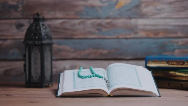 Islamic concept - The Holy Al Quran with written Arabic calligraphy meaning of Al Quran and a beautiful Arabian lamp, Arabic word translation : The Holy Al Quran (holy book of Muslim)