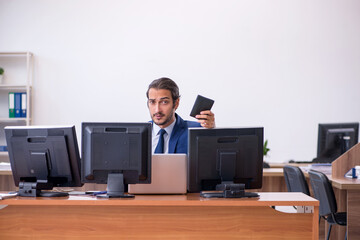Young male employee in multitasking concept