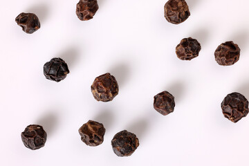 whole black pepper corn closeup macro on white background