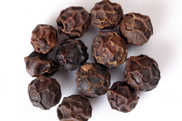 whole black pepper corn closeup macro on white background