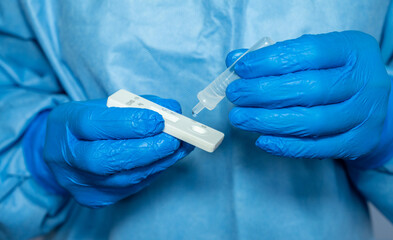Close up of healthcare worker squeezing drops of fluid after doing nasal swab for testing covid-19...
