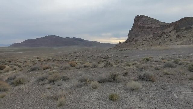 Cloudy bare landscape with mounts and rocks. Panning shot of prairie in Western Utah