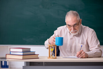 Old male teacher in time management concept