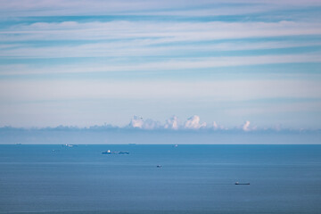 Cargo container ship on ocean horizon far away