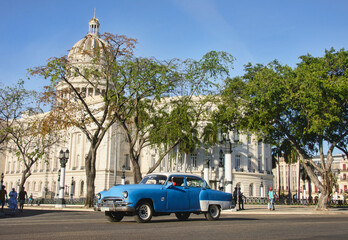 Classic auto drives past the Capitolio building, Havana, Cuba.