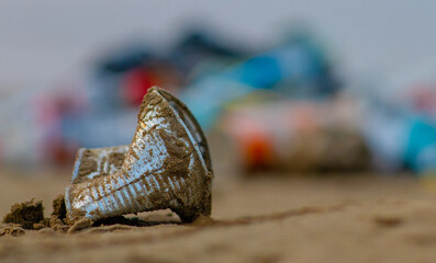 Used tin lying on a beach of a sea. Environmental pollution. Ecological problem. Empty space for text