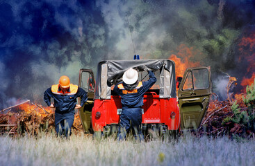 Firefighters with the inscription in Russian "Emercom of Russia" extinguish a forest fire in the reserve on a summer day