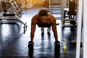 Muscular young man doing push up in the gym, Athletic man doing exercise, Man working out of bodybuilding training, Sport fitness and healthy lifestyle.