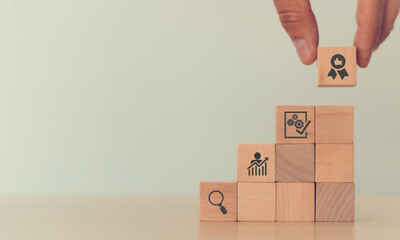 Quality control concept in industry. .Man's hand puts the wooden cubes stacked in stairs with...