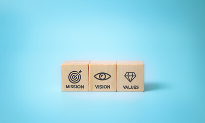 Mission vision values icon design on modern flat wooden cubes with beautiful blue background. Copy...
