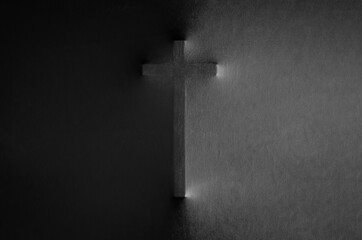The cross pressing through black fabric with shine and dark side for Halloween background concept.