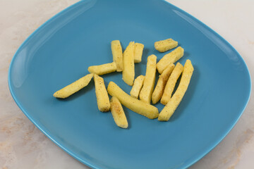 Black truffle potato fries on blue snack plate on table