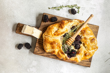 Baked brie cheese and blackberry open pie galette with thyme and honey.