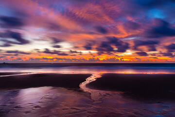Twilight scene of asian beach with flowing water and clouds.