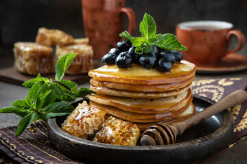 Delicious homemade pancakes   and tea cup on dark background