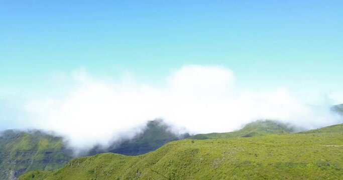 Fluffy White Clouds Over Summit Of Green Mountain From Levada do Alecrim In Rabacal, Madeira, Portugal. - wide shot