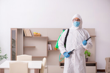 Fototapeta na wymiar Young male contractor disinfecting at home