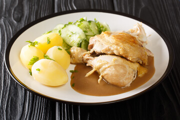 Grydestegt Kylling danish Pot-roasted Chicken with potatoes, cucumber salad, and sauce closeup in the plate on the table. Horizontal