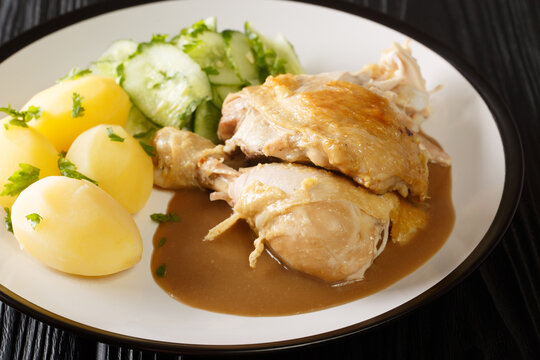 Denmark food Gammeldags Kylling fried old-fashioned chicken with boiled potatoes and cucumber salad close-up in a plate on the table. horizontal