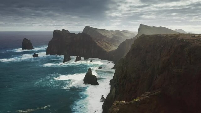 Madeira Islands, Portugal. Astonishing panorama of scenic landscape during sunrise. Drone footage of rocky volcanic cliffs surrounded with the Atlantic Ocean. High quality 4k footage