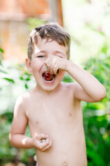 Little boy holds cherries in his mouth - 452648012