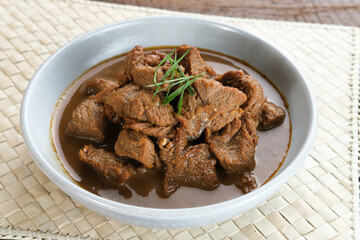 Daging Kelem is a traditional food from Central Java, Indonesia, made from beef, coconut milk and spices. It tastes sweet and savory. Served in bowl, close up.
