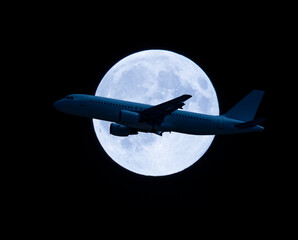 plane flying in front of the full moon. horizontal banner on black