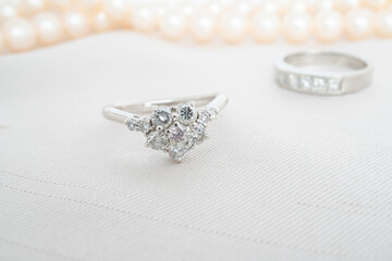 2種類のダイヤモンドリングと背景にパールのネックレス