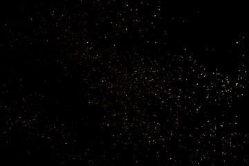 Golden abstract bokeh on black background.