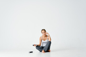 Fototapeta na wymiar woman in sports uniform sitting on the floor dumbbells exercise workout gym