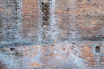 Brick wall with an inlaid arch on an old building